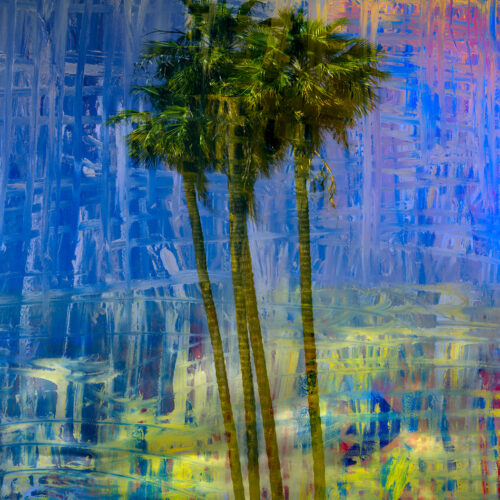 four tall palm trees stand together in the foreground, set against a vibrant, abstract background of swirling blue, yellow, and orange colors that create an energetic, painted effect.