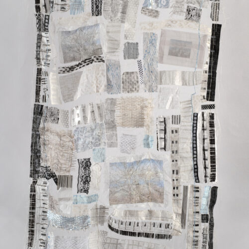 a textile artwork made of patchwork fabric pieces in shades of white, gray, and black, with various patterns and textures. some patches include tree imagery and delicate lace, all arranged in an abstract, organic composition.
