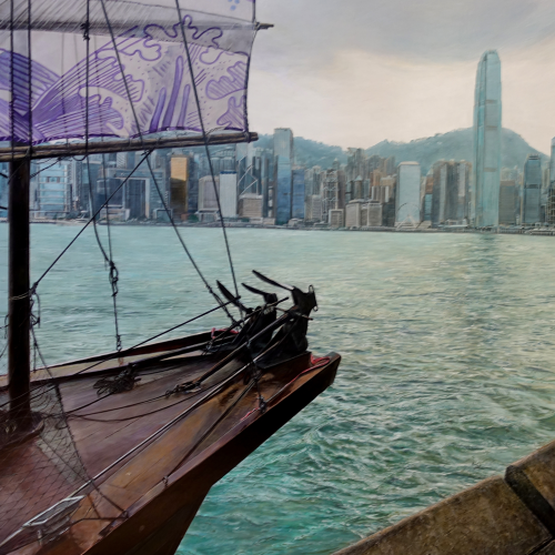 A traditional sailboat with purple sails is docked near the shore, with a modern city skyline and tall buildings visible across the water under a cloudy sky.